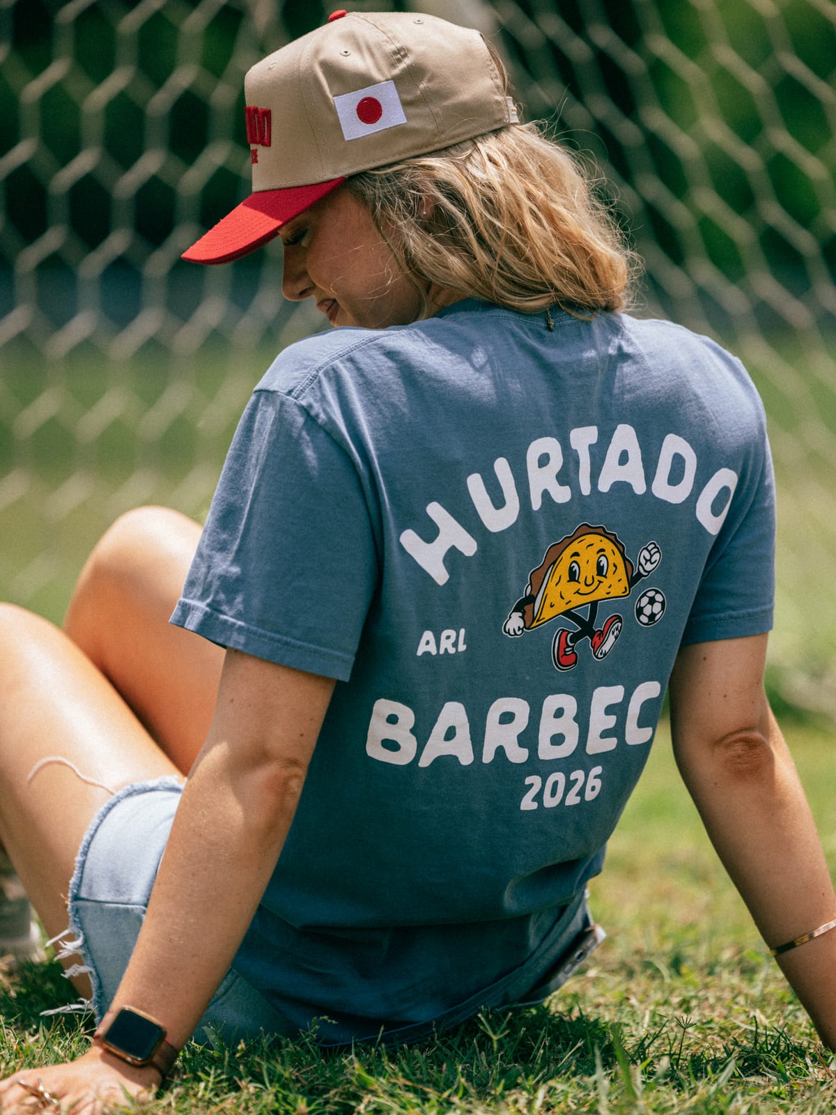 Soccer Taco Tee in faded blue, back badge worn, seated